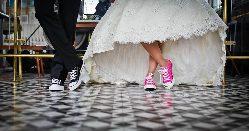 Pies de unos novios con zapatillas